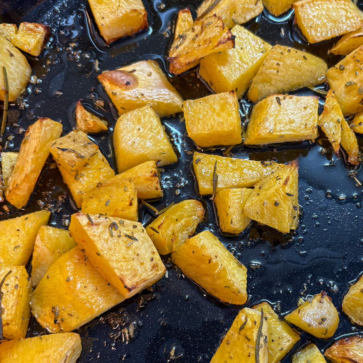 Roasted turnips on a baking tray after roasting with rosemary and herbs