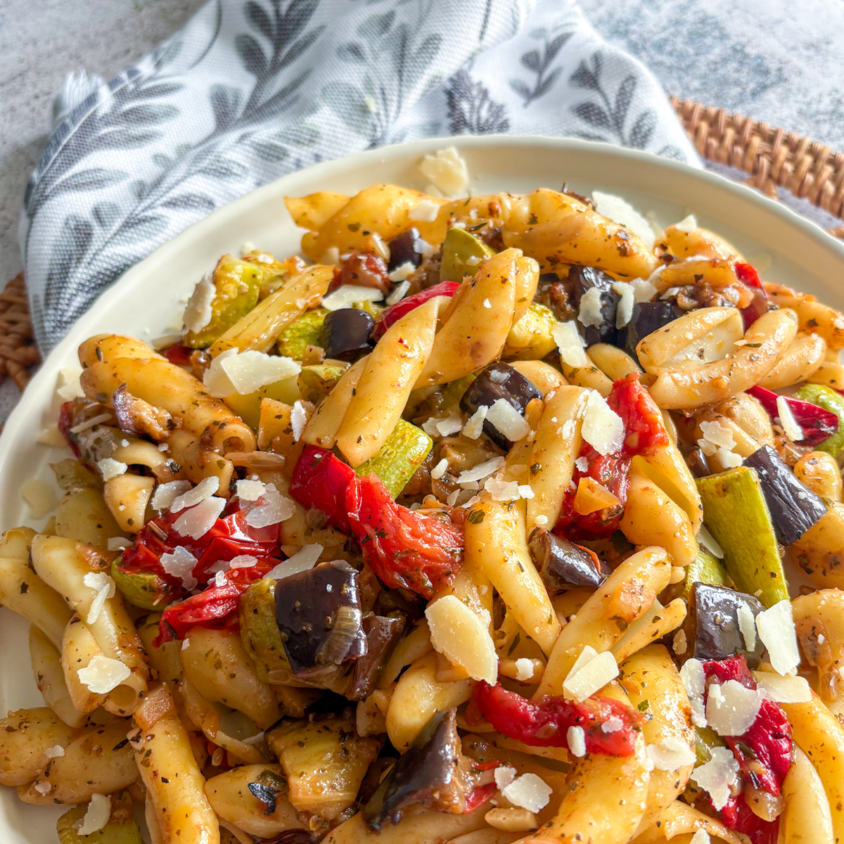 Close-up of roasted vegetable pasta with tube pasta, Italian herbs and shaved parmesan cheese