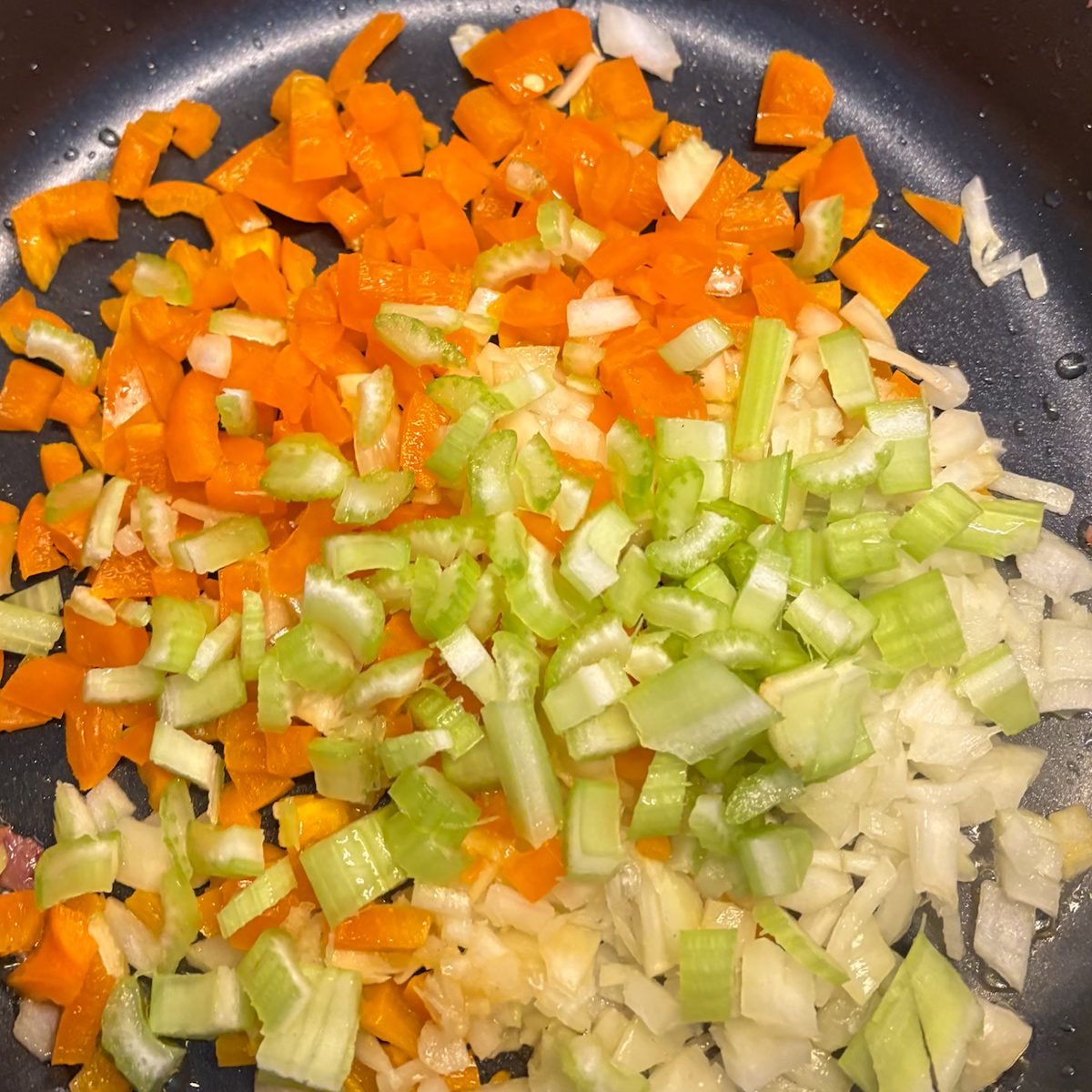 Chopped onion, pepper and celery for breakfast dirty rice in a skillet