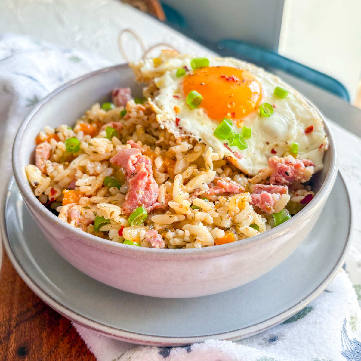 Savoury breakfast dirty rice with ham, veggies and a soft fried egg on top