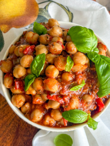 Easy chickpeas in tomato sauce close-up, tender chickpeas in herby red sauce with basil