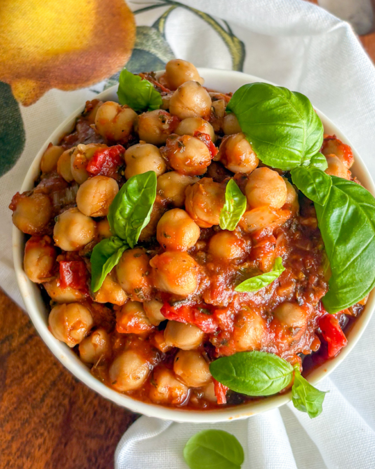 Easy chickpeas in tomato sauce close-up, tender chickpeas in herby red sauce with basil