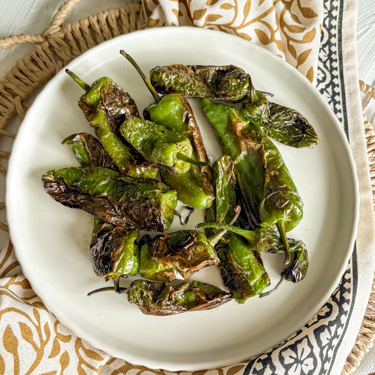 Charred padron peppers tapas served with sea salt on a plate