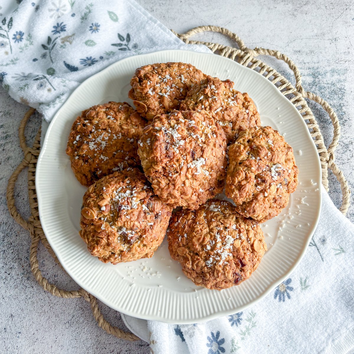 Overhead view of oatmeal cookies with dates and coconut stacked on a white plate