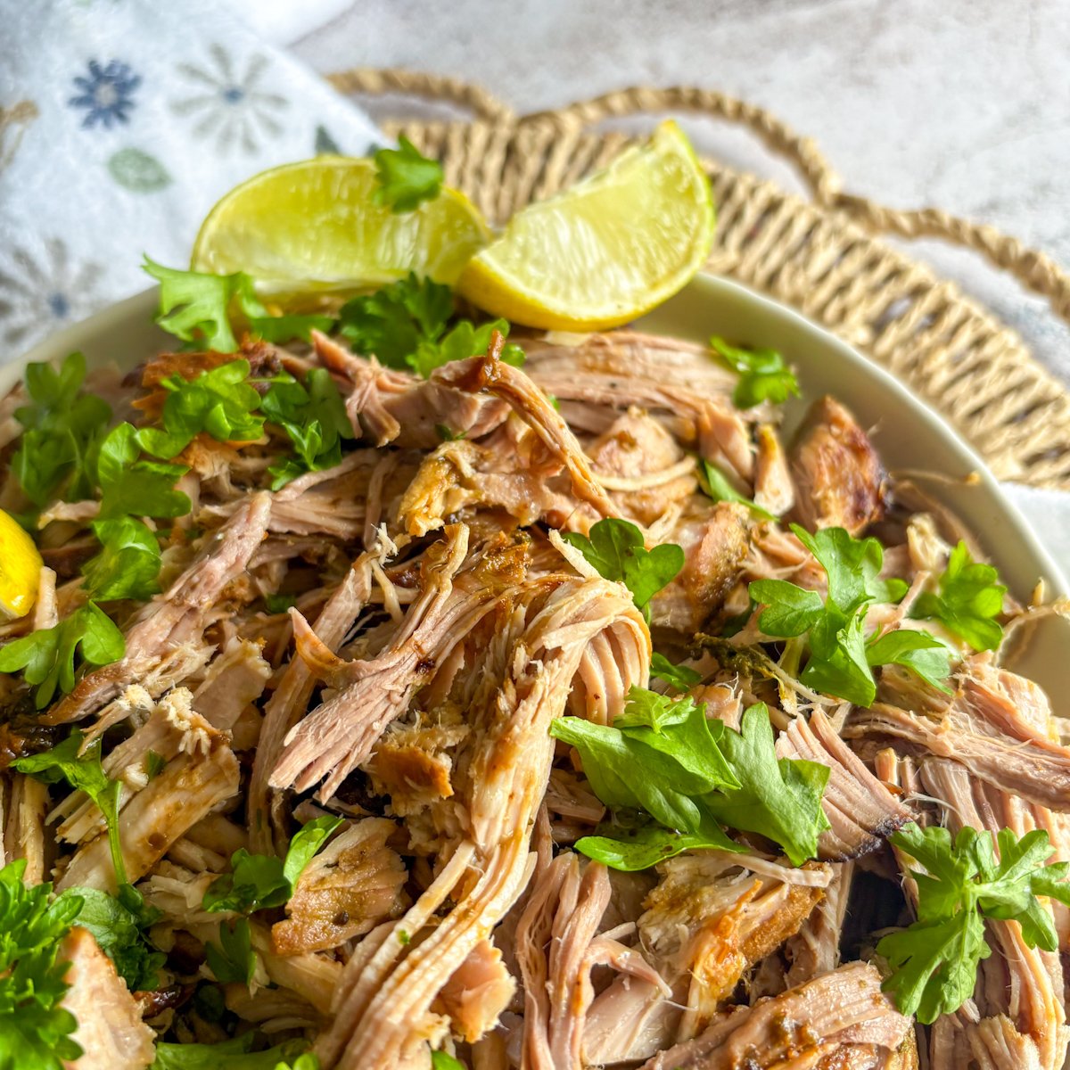 Slow cooker Cuban mojo pork shredded close-up showing juicy citrus-marinated strands with parsley and lemon