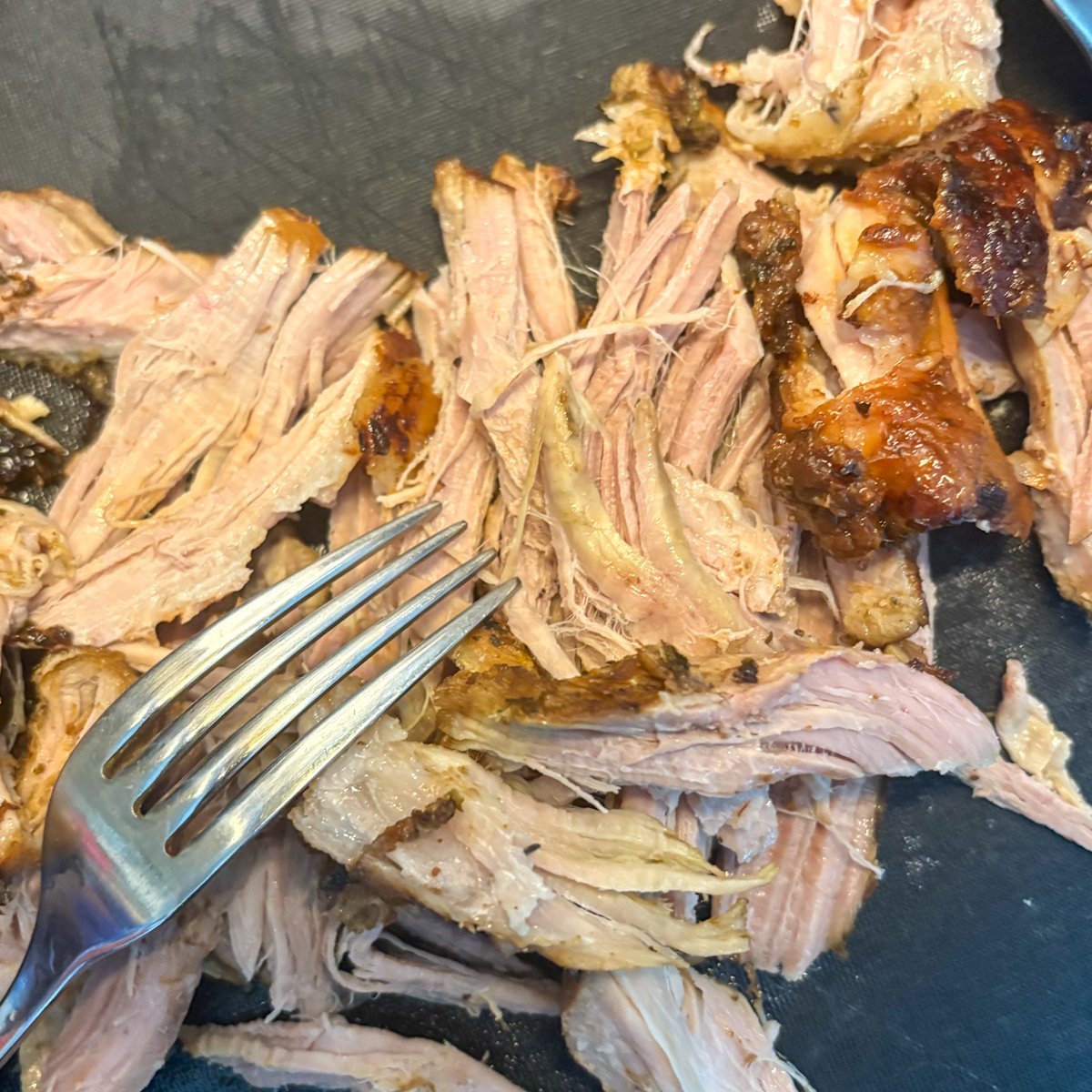 Shredding slow cooker mojo pork with a fork and crisp edges