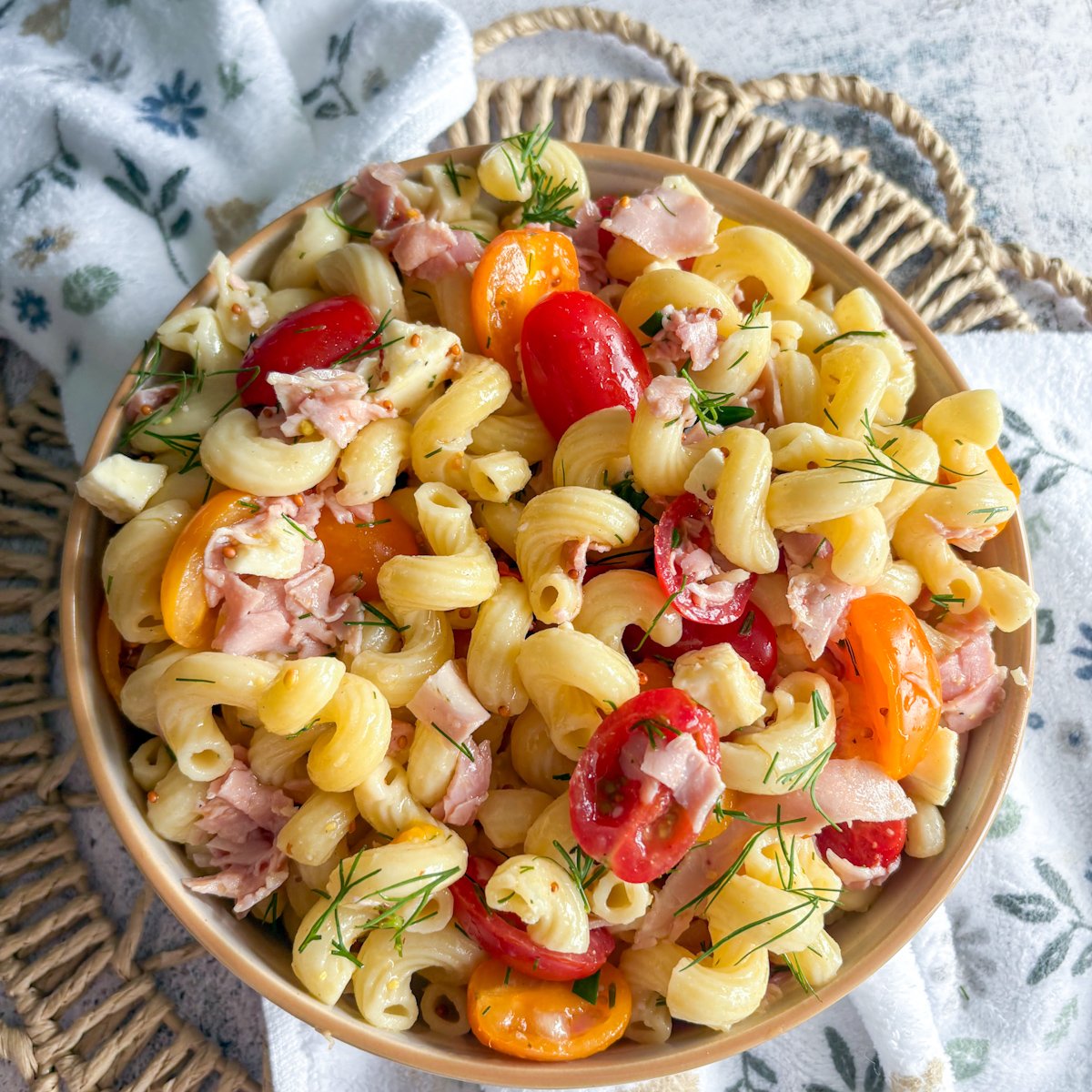 Hearty pasta salad with dill vinaigrette, tomatoes bunched at the centre