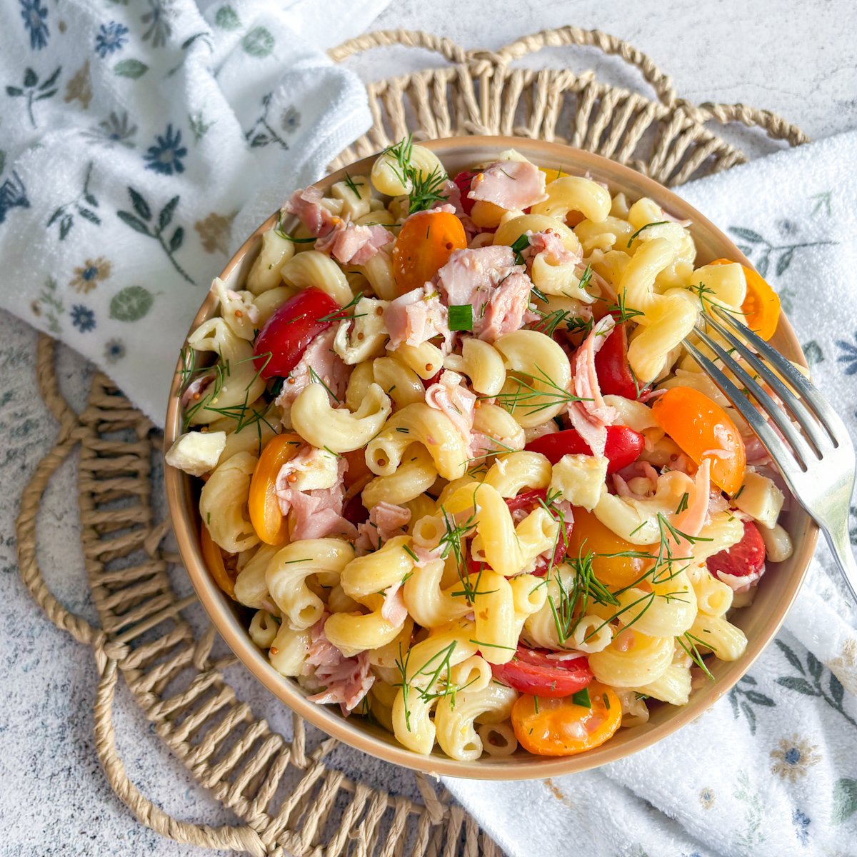 Refreshing pasta salad with dill vinaigrette, tomatoes clustered around the bowl
