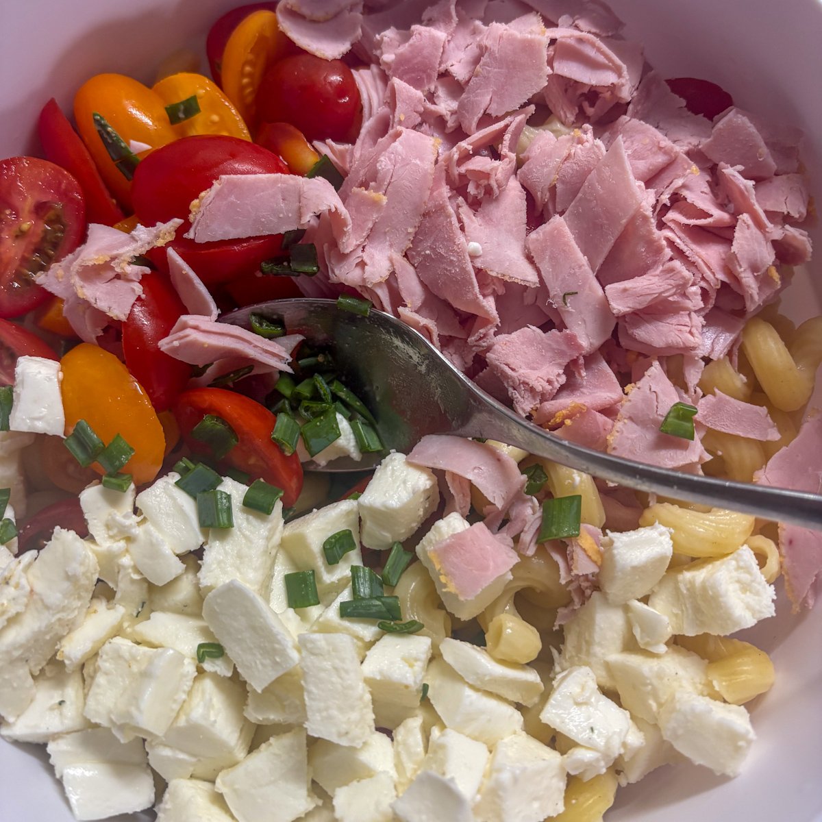Mozzarella cubes and chopped ham ready for macaroni salad with dill vinaigrette
