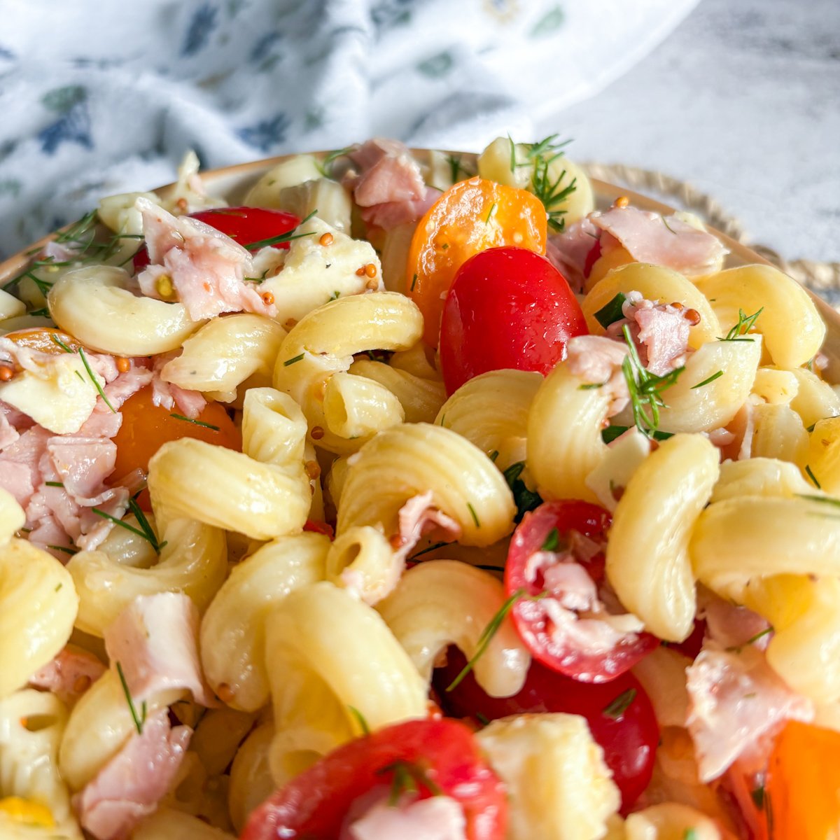 Macro shot of pasta salad with dill vinaigrette showing glossy dressing on the pasta