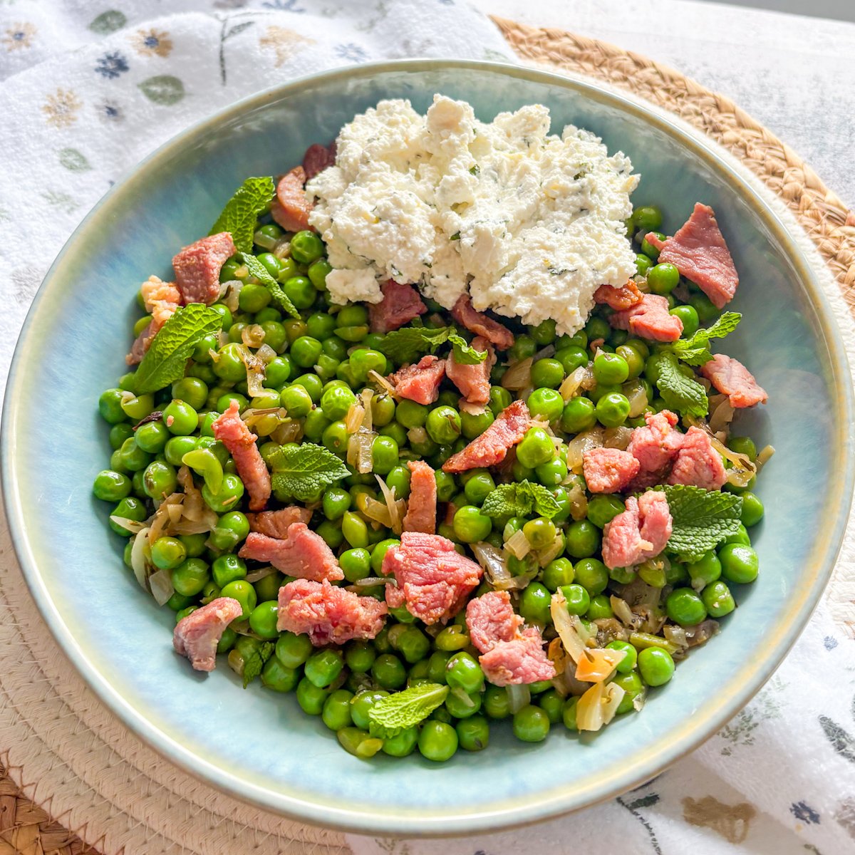 Summer peas with bacon and ricotta plated with creamy mint ricotta on the side
