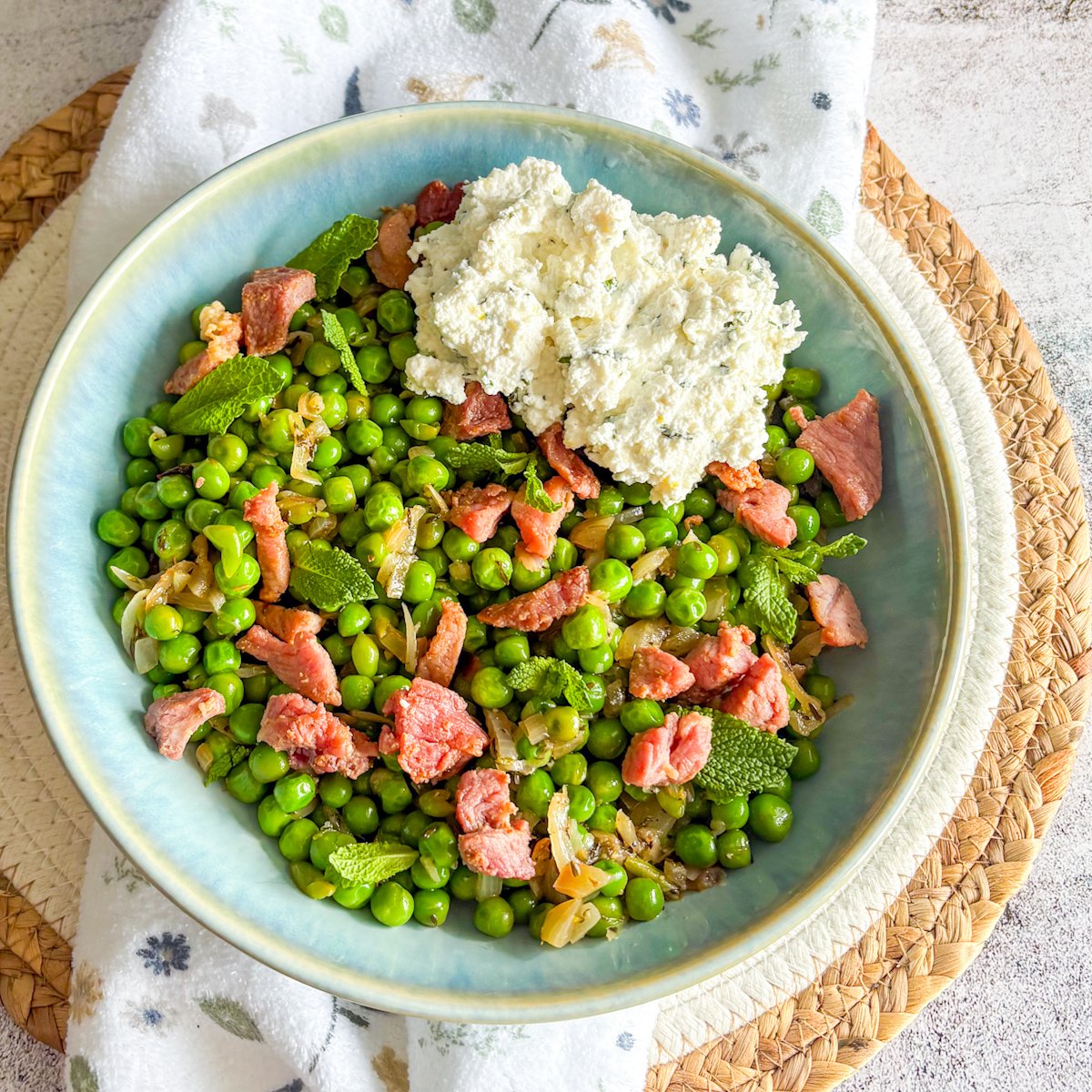 Overhead peas with bacon and ricotta topped with mint and a scoop of lemon ricotta