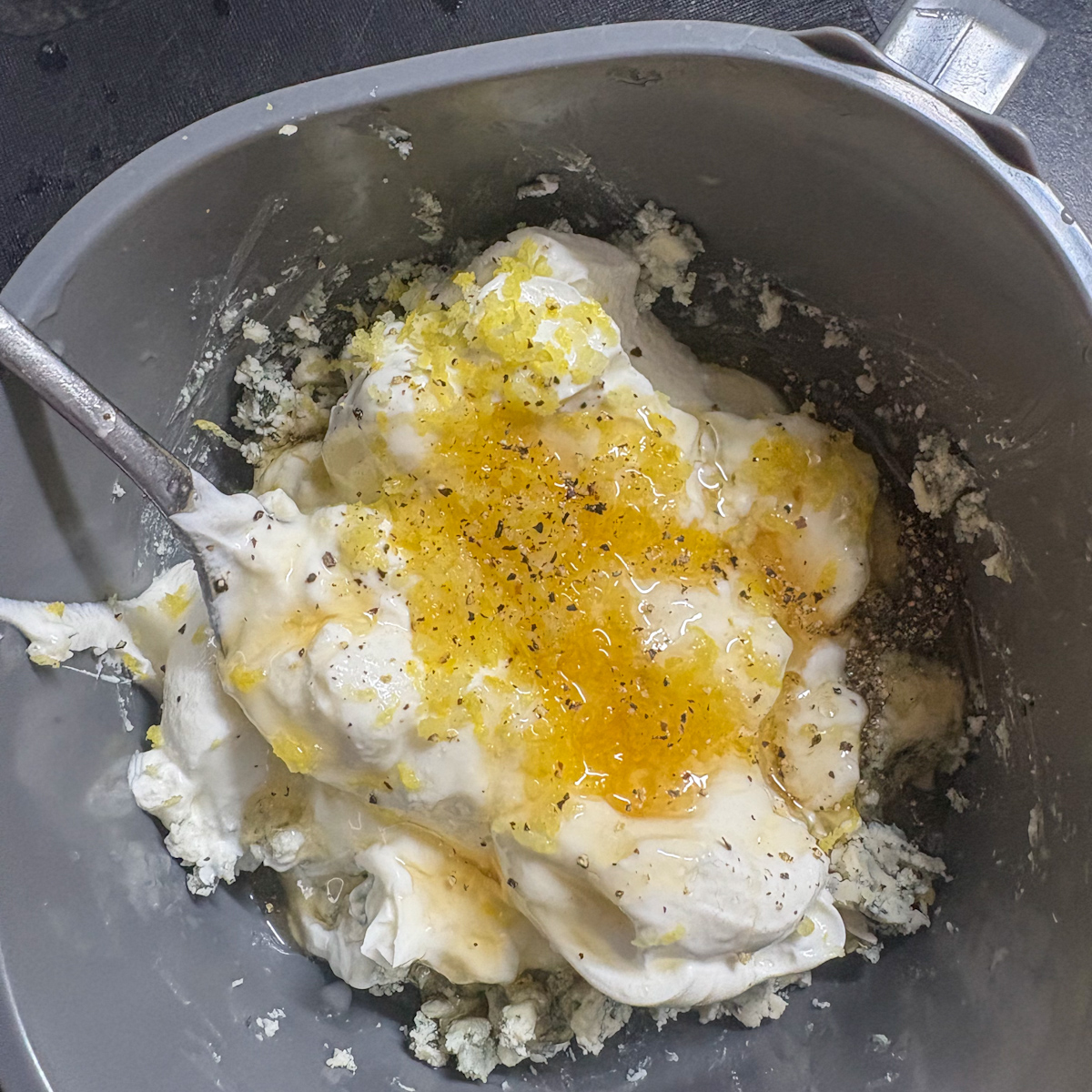 Blue cheese dressing ingredients with lemon zest, honey and pepper in a blender for pear salad
