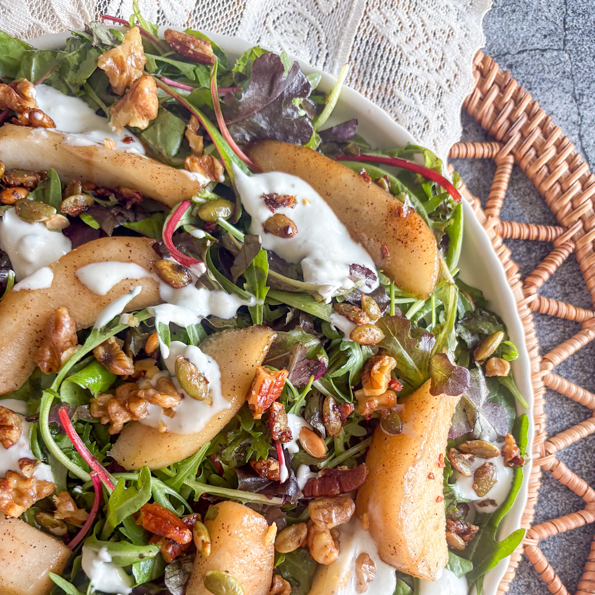 Poached pear salad with blue cheese dressing, walnuts and pumpkin seeds on fresh salad leaves
