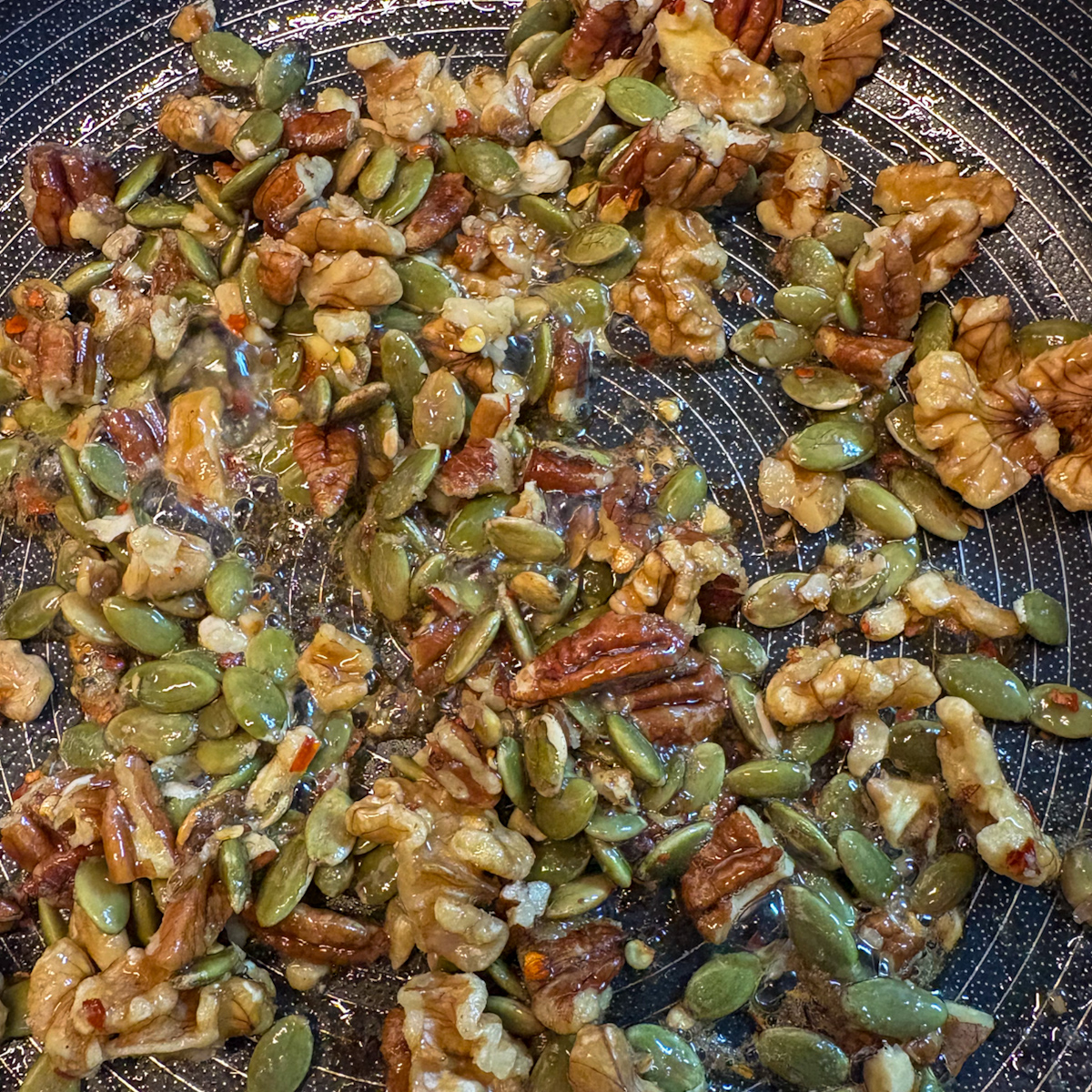 Candied pecans, walnuts and pumpkin seeds with chilli flakes for poached pear salad topping
