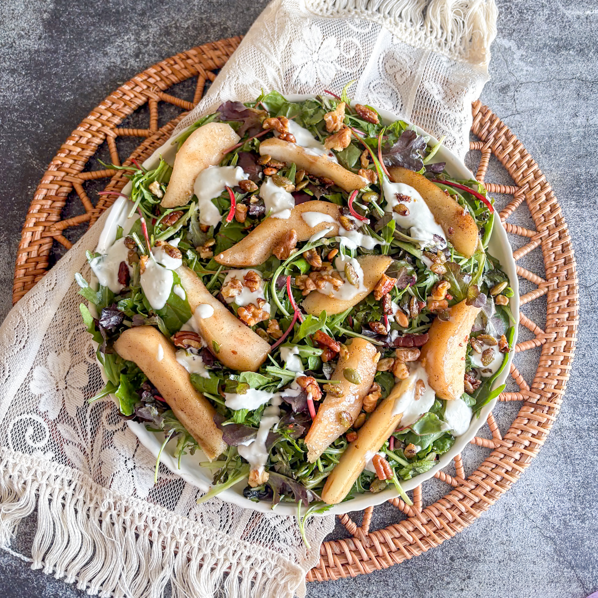 Poached pear salad with blue cheese dressing plated with pears, seeds and nuts on a platter