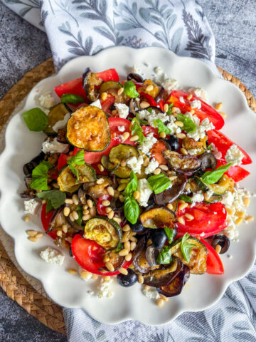 Healthy aubergine salad with roasted courgette, tomatoes, pine nuts and crumbled feta