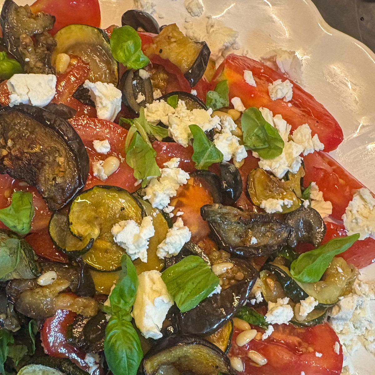 Close-up of healthy roasted vegetable salad with feta, basil and golden roasted courgette