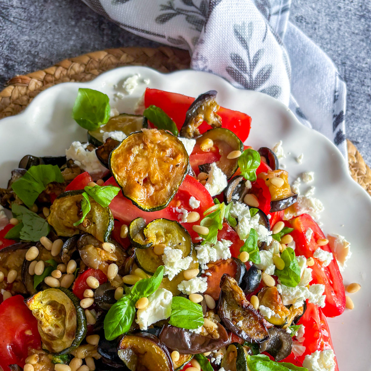 Roasted courgette and aubergine salad coated in zesty lemon dressing with olives and basil