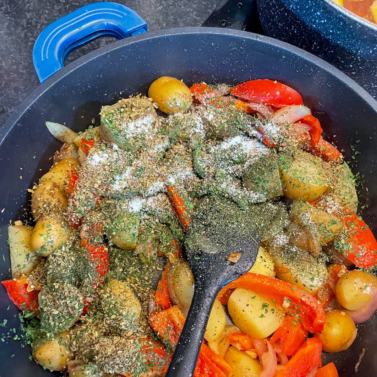 Dried herbs and salt added to potatoes and peppers for an easy sausage and vegetable stew