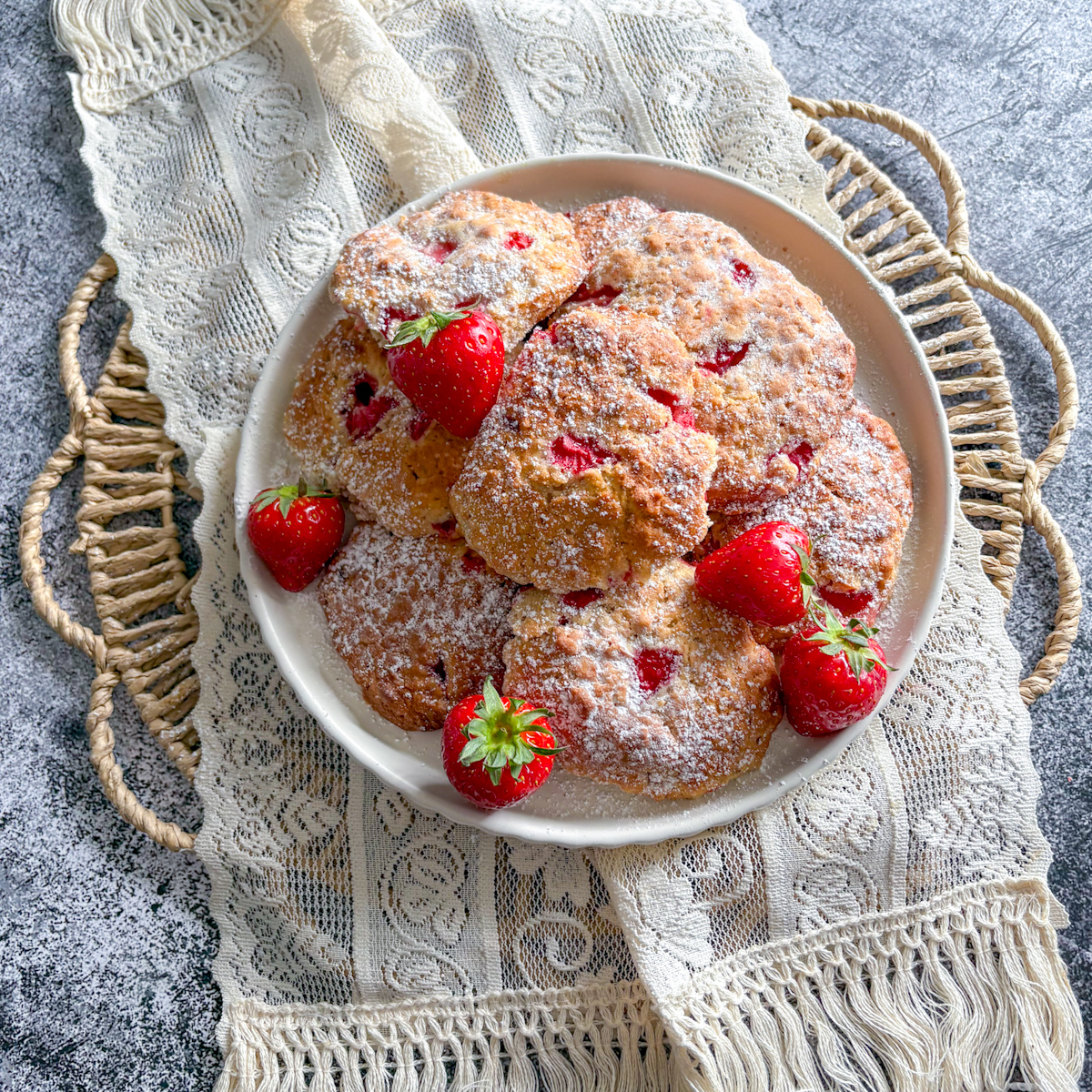 Soft fresh strawberry cookies dusted with icing sugar and whole strawberries