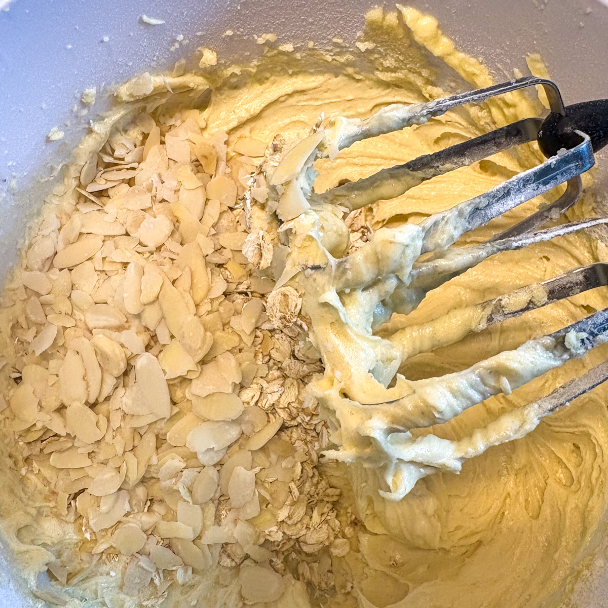 Strawberry cookie dough with jumbo oats and flaked almonds being mixed