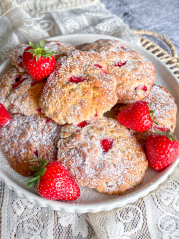 Homemade strawberry oatmeal cookies arranged on a plate with fresh strawberries
