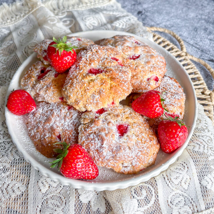 Homemade strawberry oatmeal cookies arranged on a plate with fresh strawberries