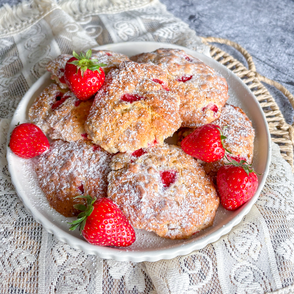 Homemade strawberry oatmeal cookies arranged on a plate with fresh strawberries