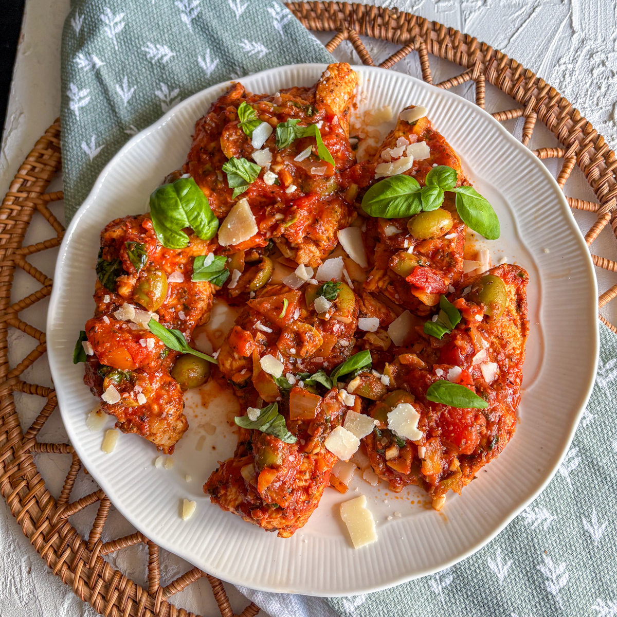 Italian turkey steaks in tomato and basil sauce topped with green olives, basil and parmesan shavings