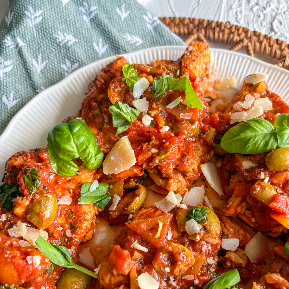 Close-up of Italian turkey steaks in rich tomato sauce with basil leaves and parmesan