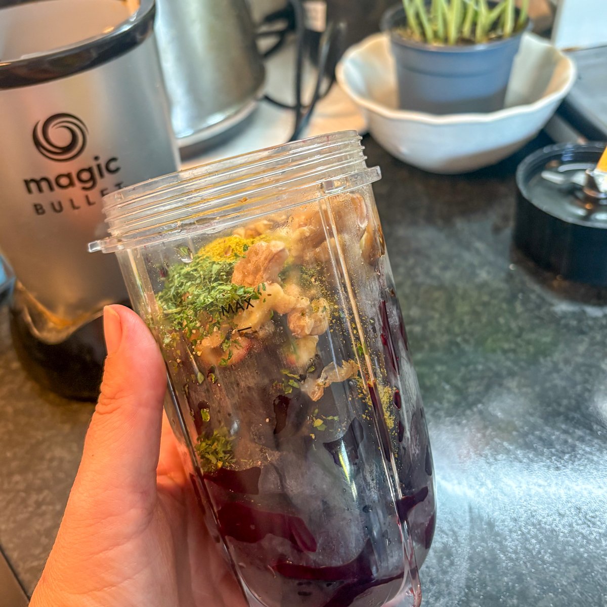 Blender cup filled with roasted beetroot, walnuts and herbs ready to blend into beetroot and walnut dip