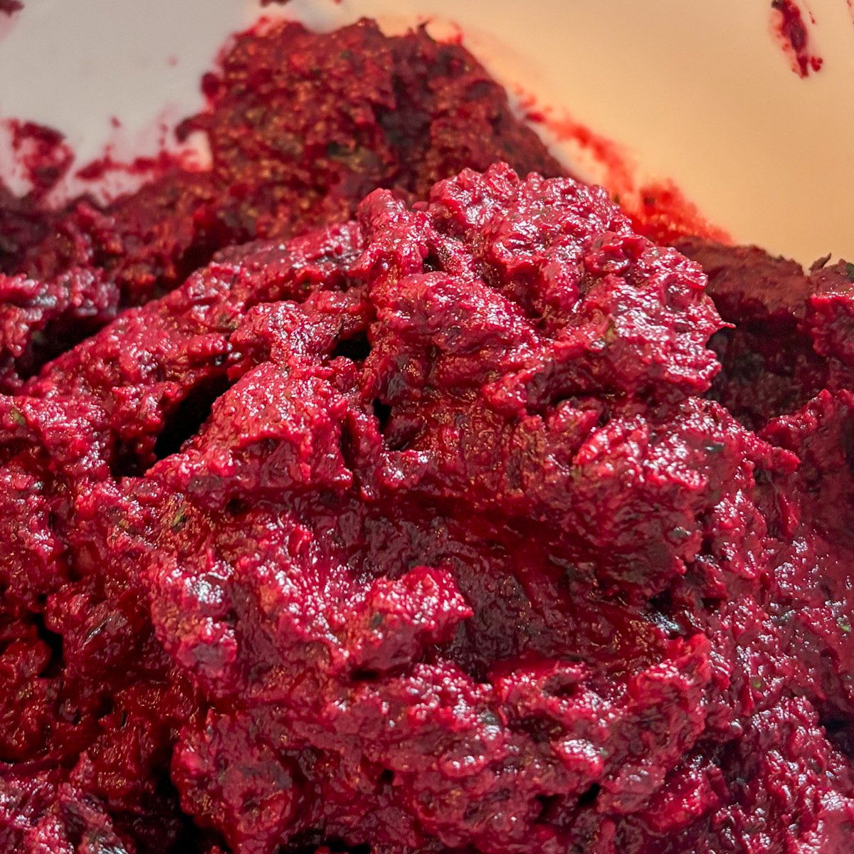Beetroot and walnut dip extreme close up showing the glossy, velvety blended texture in vivid magenta
