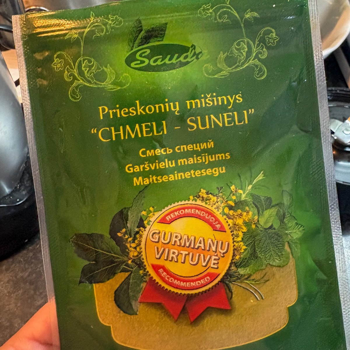 Khmeli-suneli Georgian spice blend packet used to season beetroot and walnut dip, held in hand in the kitchen
