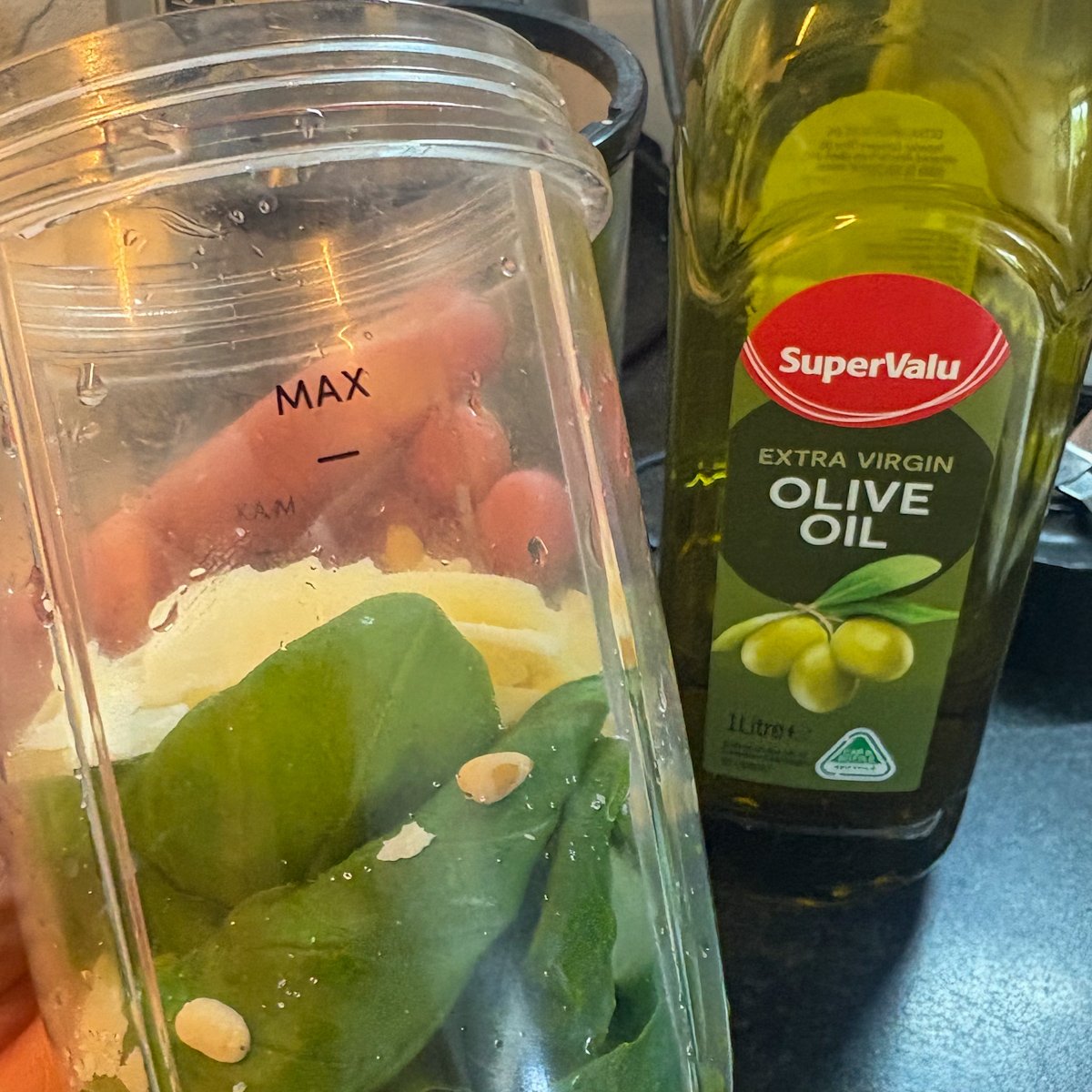 Basil, pine nuts and olive oil in a blender to make fresh pesto for pesto pasta salad