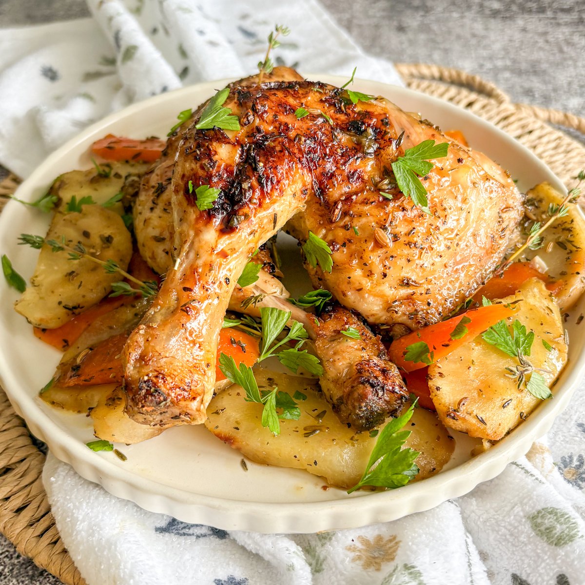 Budget chicken legs with vegetables on a cream plate with roasted carrots and parsnips