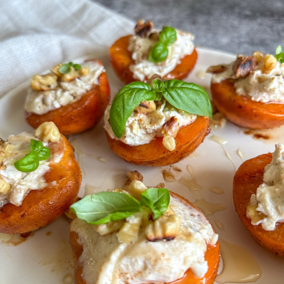 Grilled apricots, golden and tender, with rich mascarpone cream, toasted walnuts and fresh basil leaves