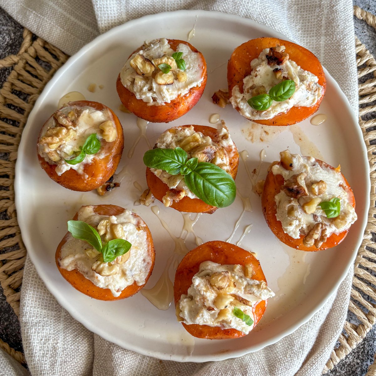 Grilled apricots with rich mascarpone cream and crunchy walnuts, warm and lightly caramelised on a white plate