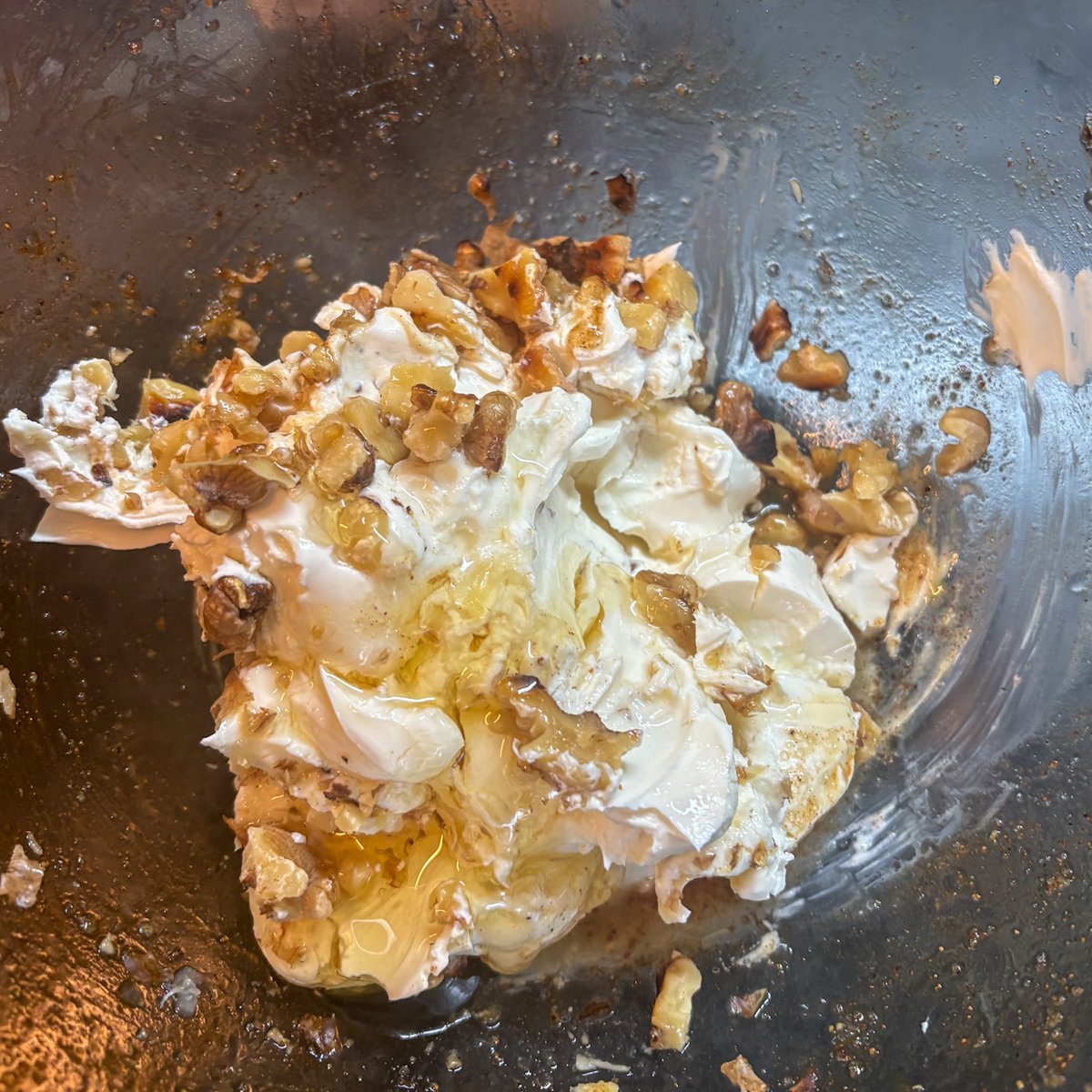 Creamy mascarpone whisked with golden honey and crunchy chopped walnuts in a glass bowl