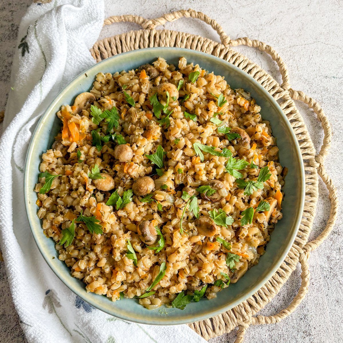 One-pan pearl barley with mushrooms served in a rustic blue bowl