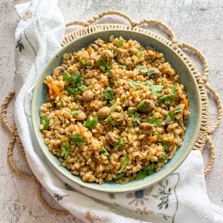 Budget pearl barley with mushrooms garnished with fresh parsley leaves