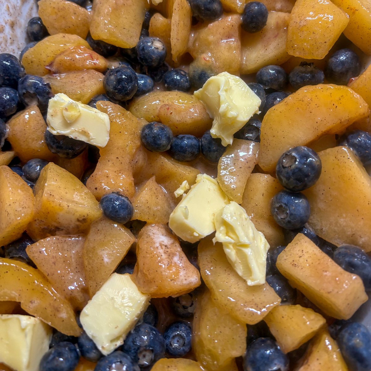 Plum and blueberry filling with chunks of butter, spices and fresh berries before baking