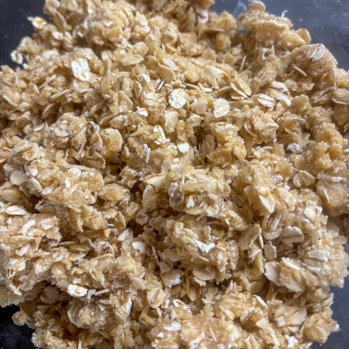 Close-up of buttery oat crumble topping ready to scatter over plum and blueberry filling
